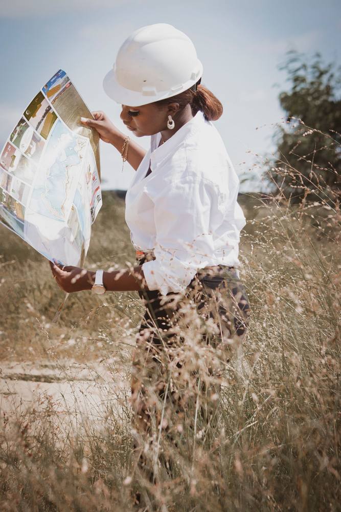 An engineer studying site plans in the field, Angola