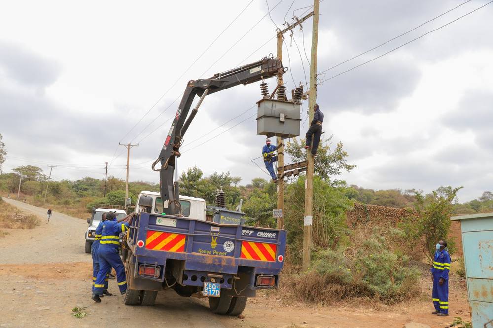 A utility crew servicing power lines from a truck crane